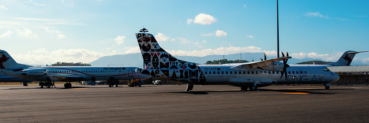 Two New Guinea aeroplanes sit on the airfield.