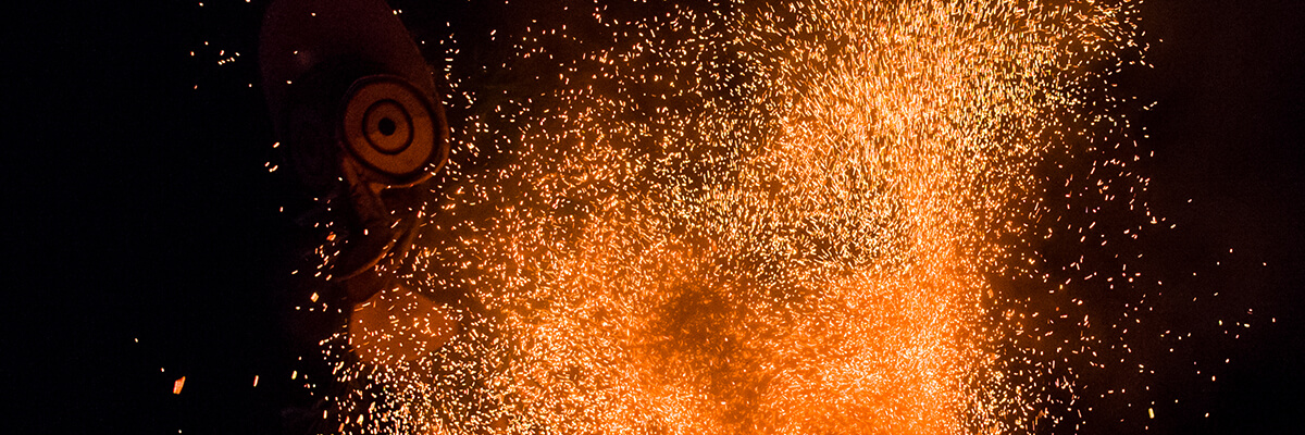 A masked face appeares out of burning sparks